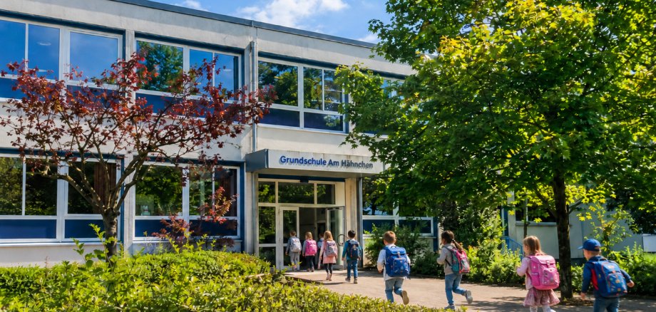 Kinder laufen in ein Schulgebäude