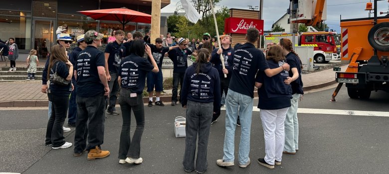 Tanzende Jugendliche vor dem Kirmesbaum
